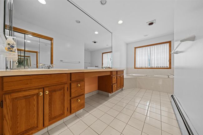 Bathroom with double vanity, recessed lighting, baseboard heating, tile patterned flooring, and a garden tub | Image 27