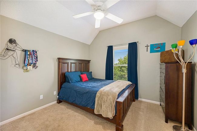 Bedroom with vaulted ceiling, light carpet, a ceiling fan, and baseboards | Image 23