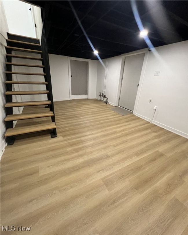 Finished below grade area with light wood-type flooring, stairway, and baseboards | Image 19
