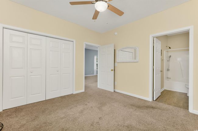 Unfurnished bedroom featuring carpet floors, a closet, baseboards, a ceiling fan, and ensuite bathroom | Image 14