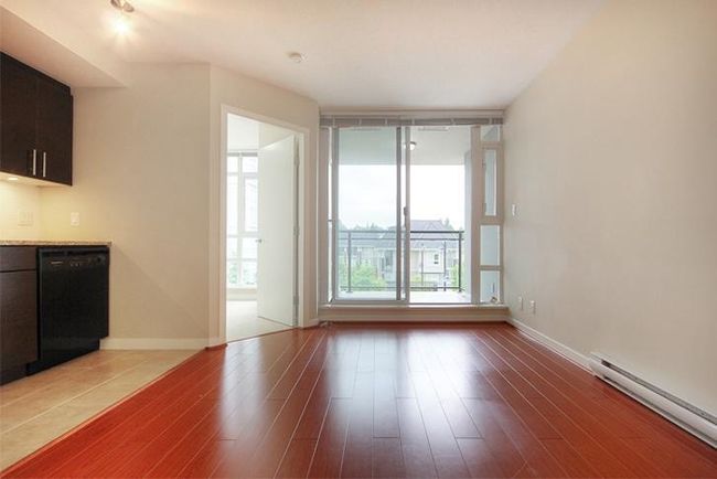 Unfurnished living room with light wood finished floors, baseboard heating, and baseboards | Image 13