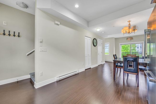 Dining room with a baseboard heating unit, a chandelier, baseboards, wood finished floors, and recessed lighting | Image 4