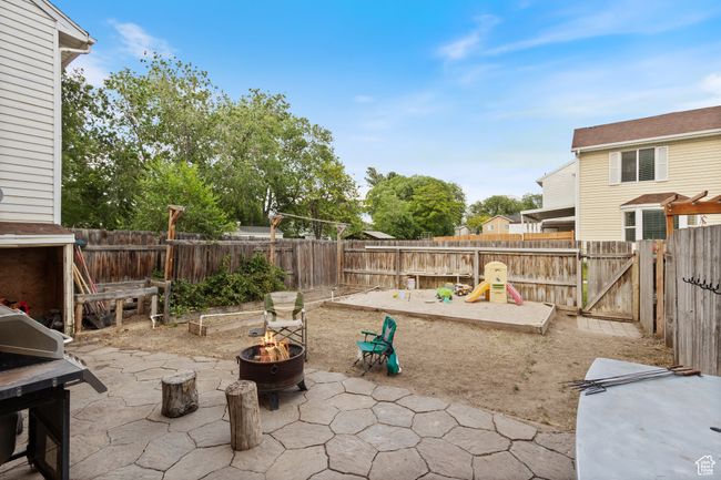 Fenced backyard featuring a fire pit, a patio area, and a grill | Image 19
