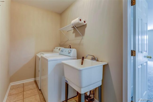 Laundry room with laundry tub and direct access to the garage. | Image 11