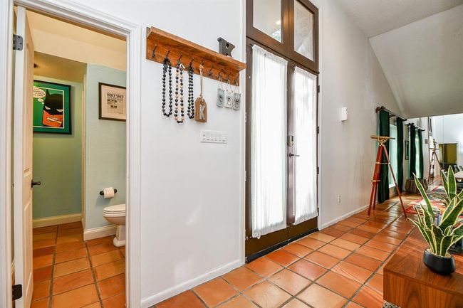 This inside view of the main entrance pleases in its linear construction, with open views to other areas, and the convenient bath, left. | Image 5