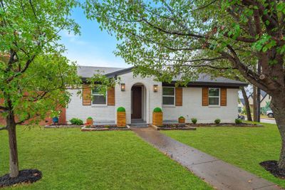 This home offers beautiful curb appeal with wood accents, new exterior lighting, fresh landscaping, a new front door and designer paint colors. Wait until you see inside! | Image 1