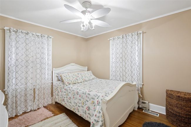 Bedroom featuring ornamental molding, baseboards, ceiling fan, and wood finished floors | Image 18