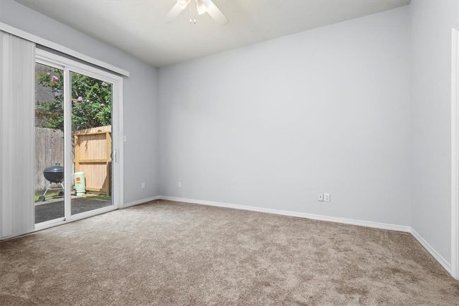 The primary bedroom has sliding glass doors to the backyard space, a large bathroom and a large walk in closet. | Image 17