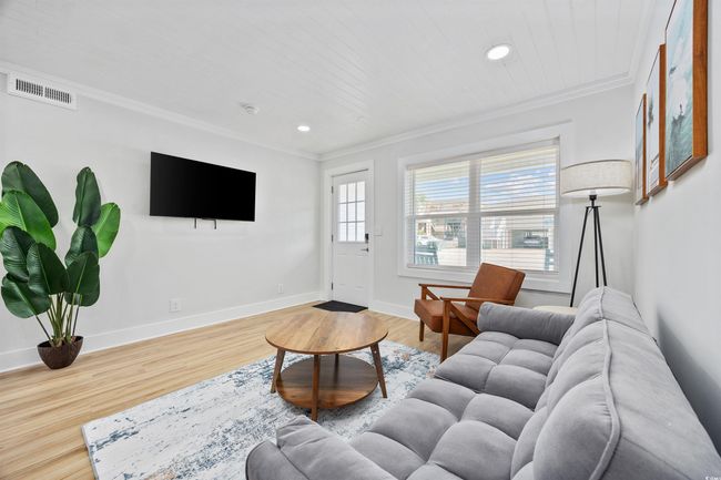 Living area featuring ornamental molding, recessed lighting, wood finished floors, and baseboards | Image 6