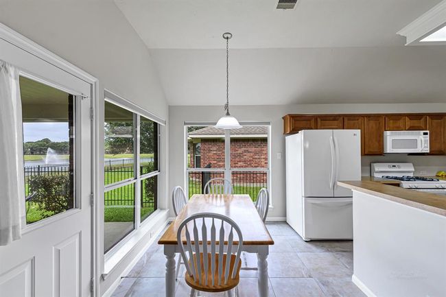 Bright and light breakfast room opens to the living room and overlooks the lake in the backyard. | Image 7