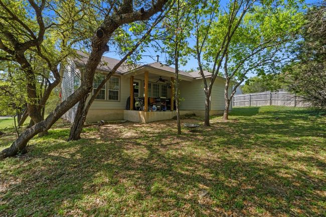 Rear view of house featuring a shaded yard, ceiling fan, and fence | Image 32