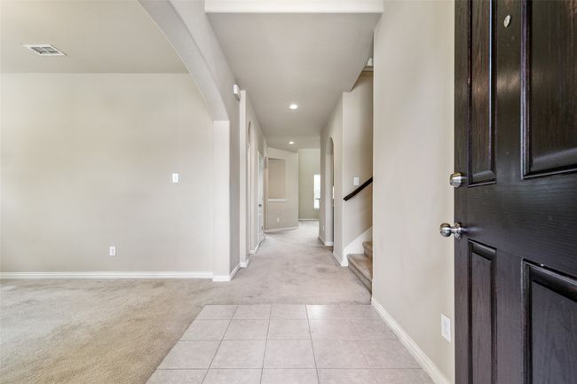 Foyer with light carpet, arched walkways, baseboards, recessed lighting, and stairs | Image 5