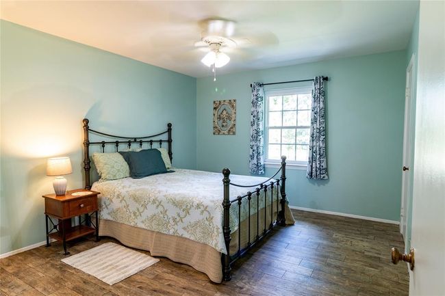 Upstairs bedroom (one of three) with vanity, view toward window. | Image 22