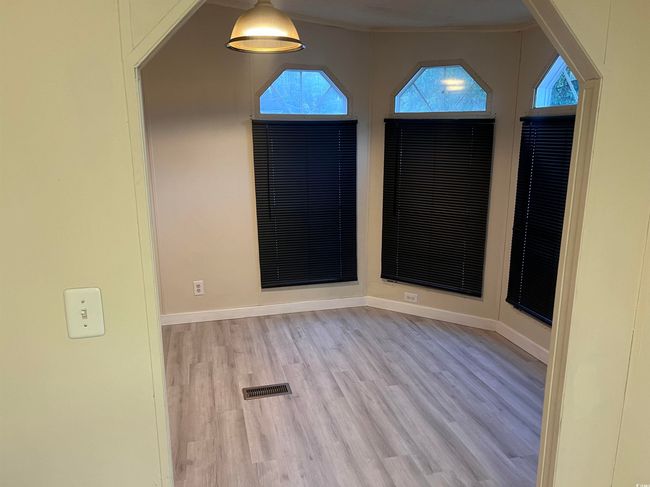 Unfurnished room featuring wood finished floors, baseboards, and lofted ceiling | Image 12