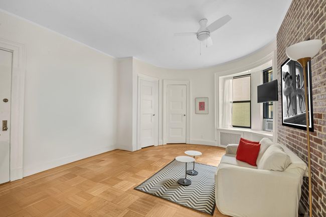 Living/sleeping area with a ceiling fan and baseboards | Image 7