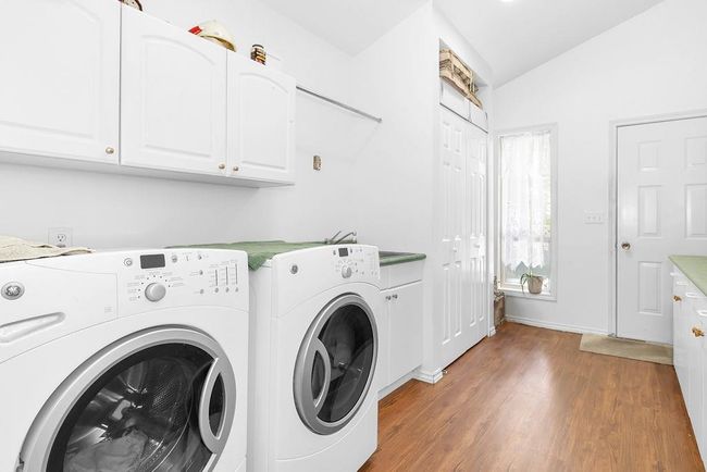 Washroom featuring separate washer and dryer, light wood finished floors, and cabinet space | Image 21