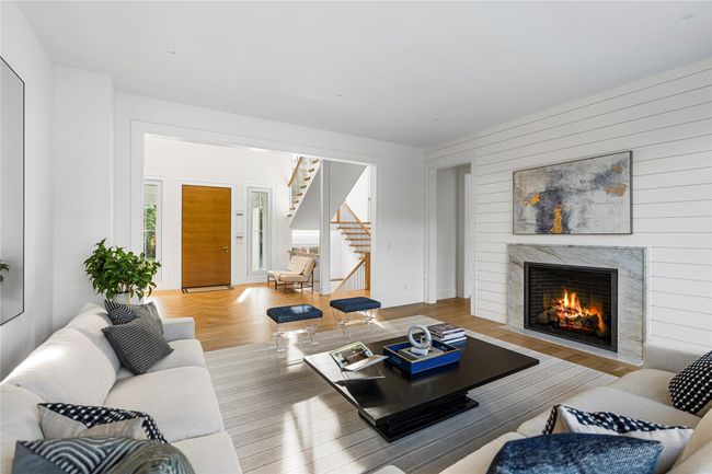 Living room with stairs, a premium fireplace, wood finished floors, and wooden walls | Image 15