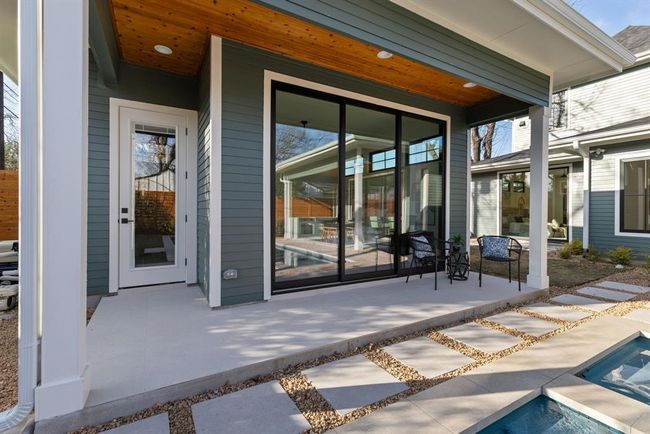 View of exterior entry with an outdoor pool and covered porch | Image 38