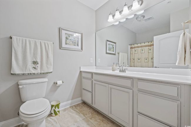 Full bathroom with vanity, toilet, baseboards, and marble look tile flooring | Image 17