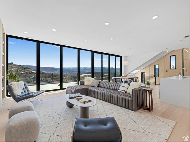 Living room featuring light wood finished floors, a mountain view, floor to ceiling windows, and recessed lighting | Image 5