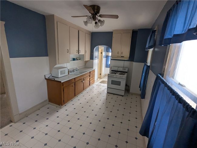 First-Floor Kitchen with white appliances, ceiling fan, and sink | Image 10
