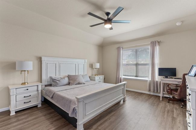 Bedroom featuring wood finished floors, a desk, lofted ceiling, and a ceiling fan | Image 14