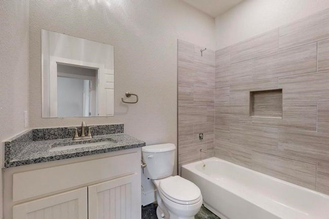 Bathroom with bathing tub / shower combination, vanity, and toilet | Image 24