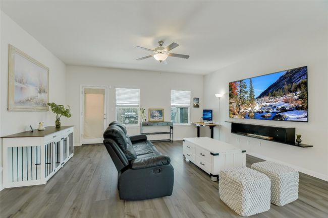 Living area with wood finished floors, a ceiling fan, and baseboards | Image 11