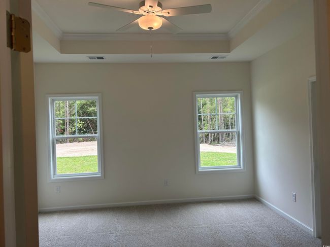 Unfurnished room with a tray ceiling, ornamental molding, carpet, baseboards, and a ceiling fan | Image 18