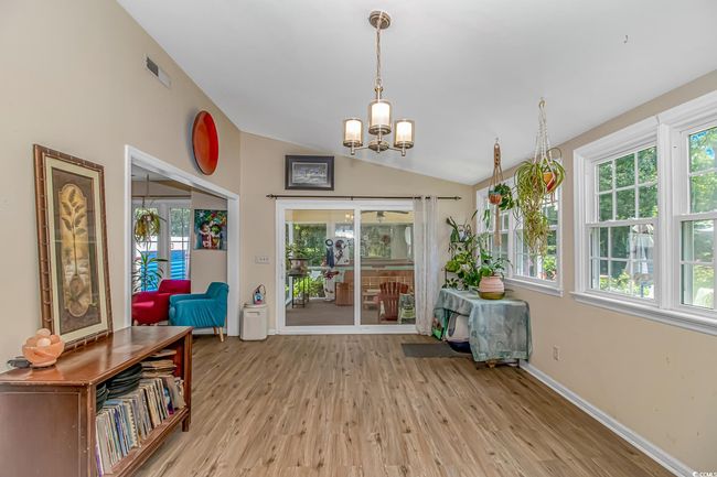 Sunroom / solarium featuring lofted ceiling, a chandelier, and healthy amount of natural light | Image 7