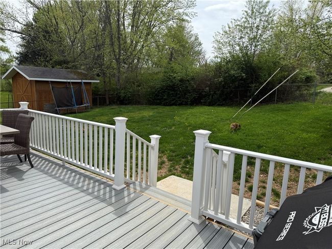 Deck with a fenced backyard, a storage shed, a yard, an outbuilding, and a trampoline | Image 22