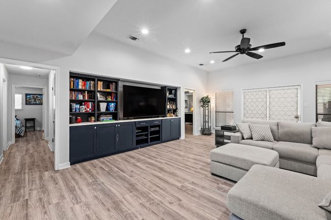 Living room with plenty of natural light, light wood-style flooring, visible vents, and ceiling fan | Image 5