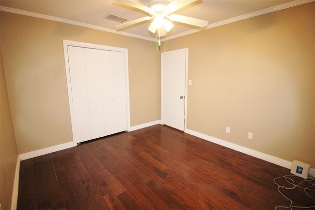 Guest Bedroom 1: Wood flooring. Closet has built-in shoe rack | Image 22