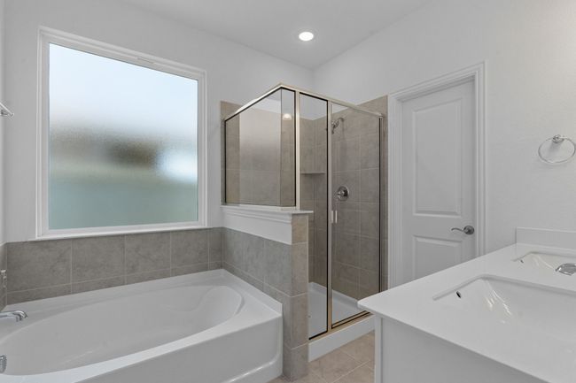 Bathroom featuring a bath, a stall shower, tile patterned flooring, and double vanity | Image 22