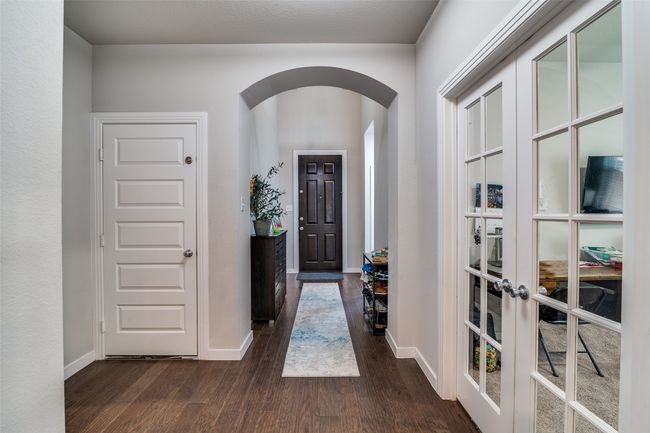 Foyer featuring arched walkways, dark wood finished floors, and french doors | Image 4