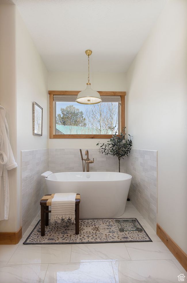 Bathroom featuring tile walls, a freestanding tub, and wainscoting | Image 13