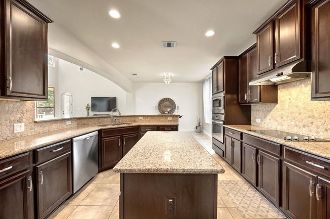 Large kitchen with stainless appliances, granite counters and walk in pantry. | Image 12
