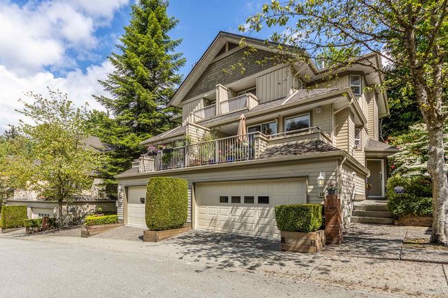 View of front of home with a balcony, concrete driveway, board and batten siding, and a garage | Image 16