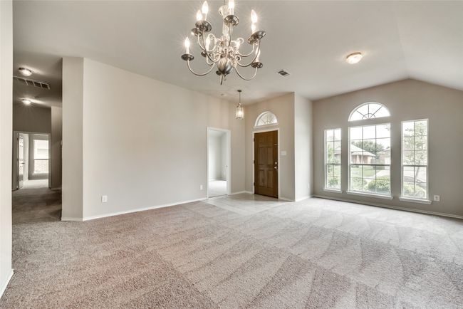 Spare room with carpet floors, a chandelier, and lofted ceiling | Image 11