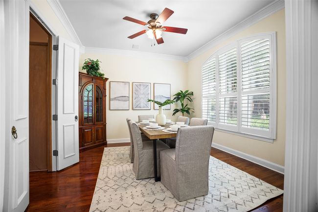 Dining space with healthy amount of natural light, ornamental molding, a ceiling fan, and dark wood-type flooring | Image 5