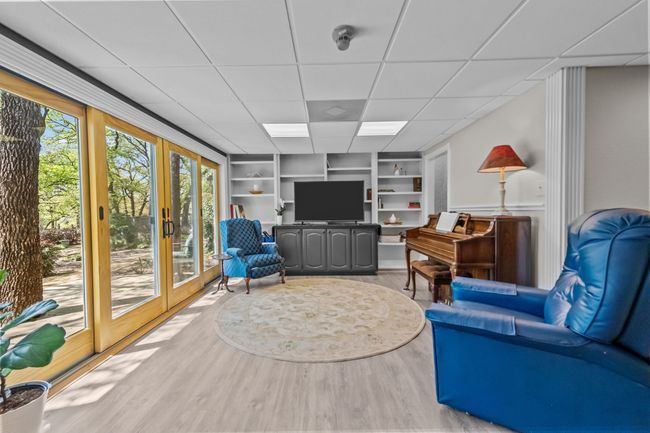 Living room featuring french doors, built in features, a healthy amount of sunlight, and wood finished floors | Image 7