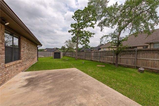 View of yard featuring a storage shed, a patio, an outdoor structure, and a fenced backyard | Image 31