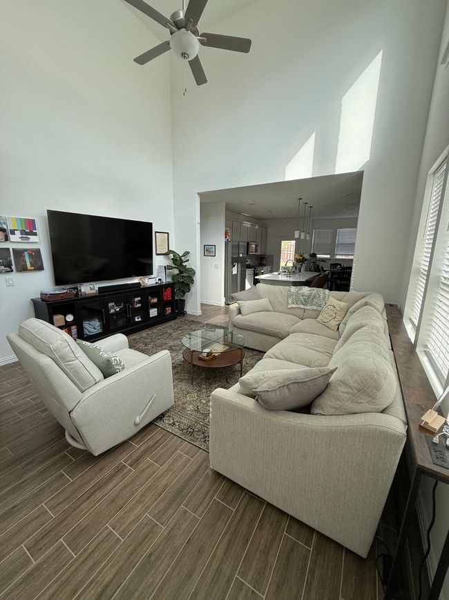 Living room with dark wood finished floors, ceiling fan, and a towering ceiling | Image 18