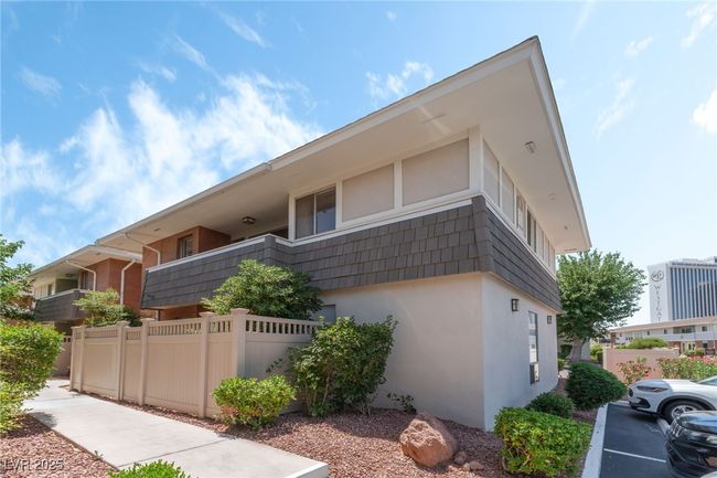 View of property exterior with stucco siding and mansard roof | Image 9