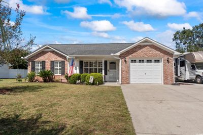 Ranch-style house featuring a garage and a front yard | Image 2