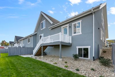 Rear view of property with a wooden deck, a yard, and cooling unit | Image 3