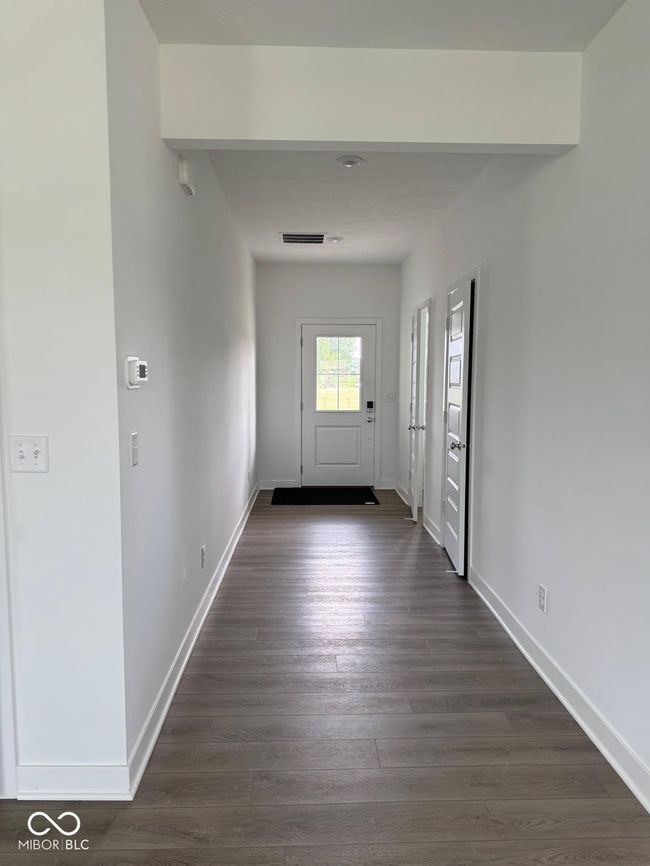 foyer entrance featuring baseboards and dark wood-style flooring | Image 5