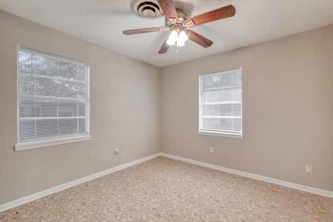 Bedroom 3 with 2 single windows replaced in Jan 2025, vinyl flooring, and baseboards and a ceiling fan | Image 18