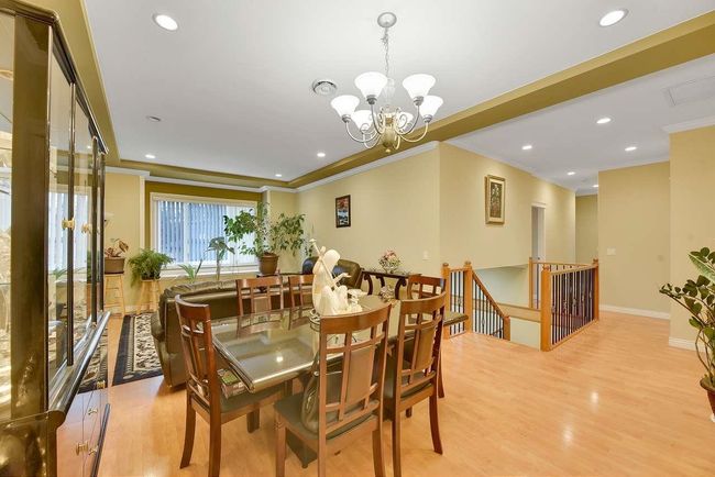 Dining room featuring ornamental molding, light wood finished floors, a chandelier, recessed lighting, and baseboards | Image 38