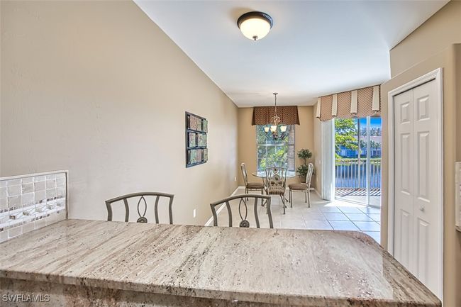Dining space with light tile patterned floors and an inviting chandelier | Image 25